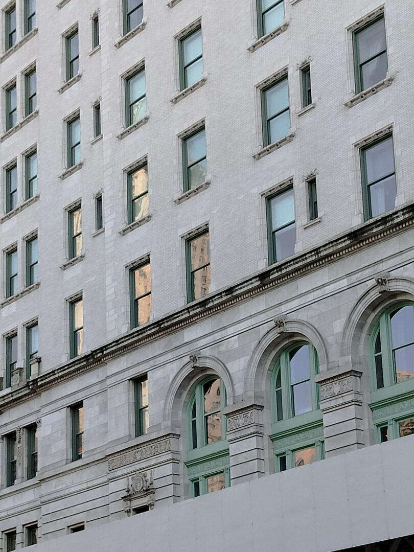 Photo of the sky reflecting off of building windows on the streets of New York.