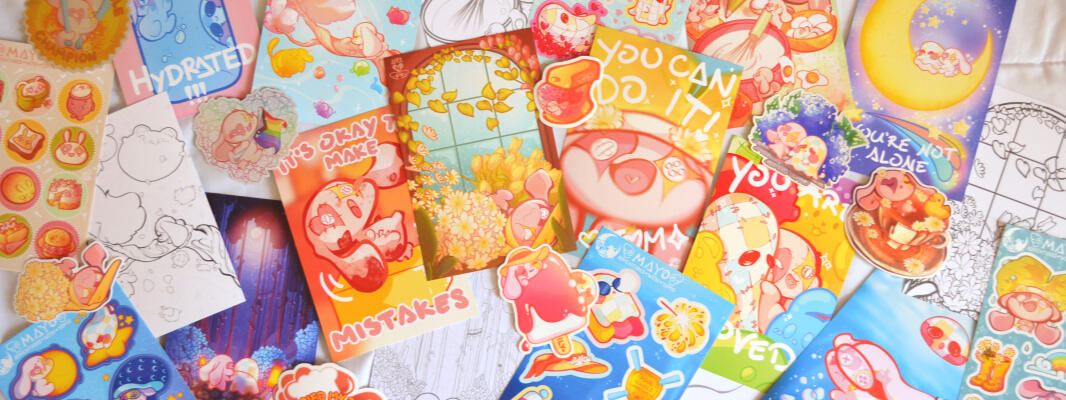 Photo of a pile of prints and stickers featuring artwork made by Aryssa.